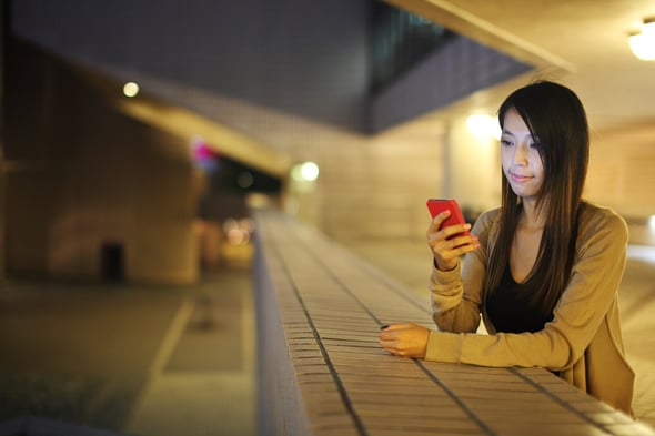 woman using mobile phone in city at night.jpeg